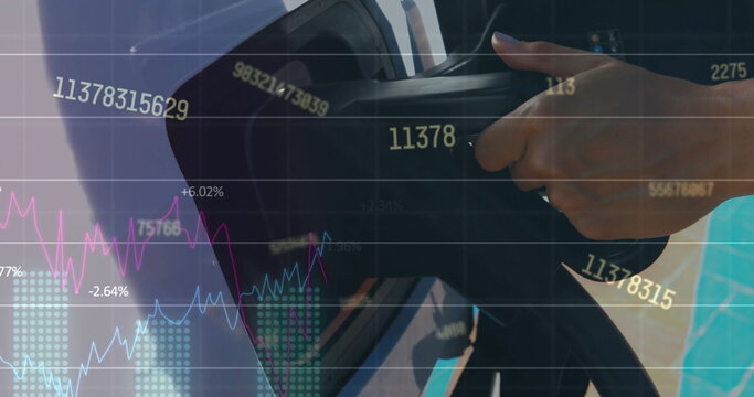 Image of financial data processing over woman charging electric car - Powered by Adobe