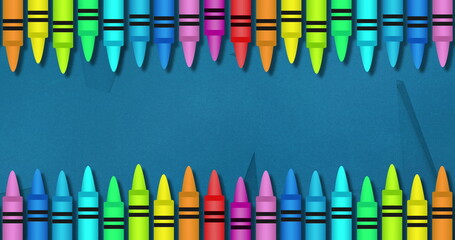 Naklejka premium Image of multiple colourful crayons on top and bottom over blue background
