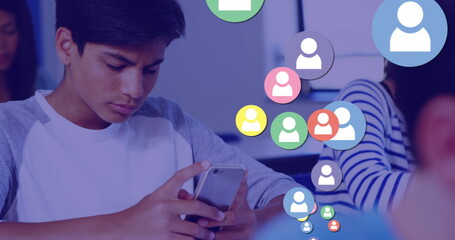 Image of people social media icons over schoolboy using smartphone during class at school
