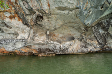 Natural stalactite and stalagmite rock stone cliff hang from cave ceiling in cave with lake river sea. Environmental explore. Landscape background. Erosion