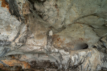 Natural stalactite and stalagmite rock stone cliff hang from cave ceiling in cave with lake river sea. Environmental explore. Landscape background. Erosion