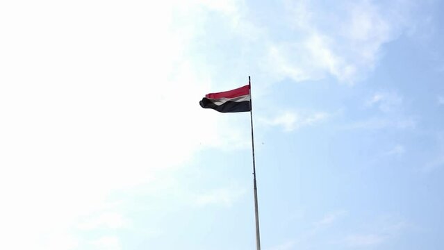 The flag is flying in the sky, the flag of the Arab Republic of Egypt is flying upwards in the clear sky, a flag pride, nobility, dignity and patriotism, and its colors are red, white and black.