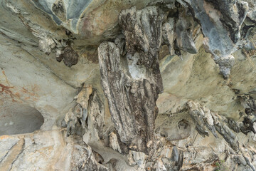 Natural stalactite and stalagmite rock stone cliff hang from cave ceiling in cave with lake river sea. Environmental explore. Landscape background. Erosion