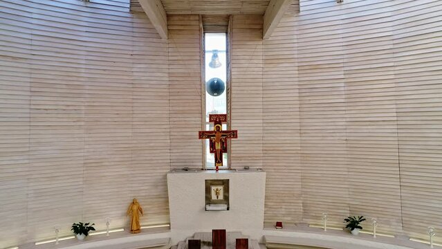 Bells ringing in modern church behind the altar with cross - interior aerial shot.