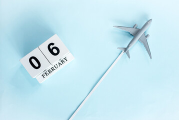 February calendar with number  6. Top view of calendar with flying passenger plane. Scheduler. Travel concept. Copy space.