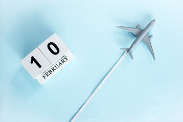 February calendar with number  10. Top view of calendar with flying passenger plane. Scheduler....