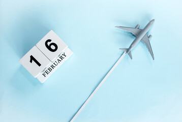 February calendar with number  16. Top view of calendar with flying passenger plane. Scheduler....
