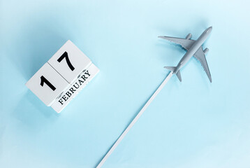 February calendar with number  17. Top view of calendar with flying passenger plane. Scheduler....