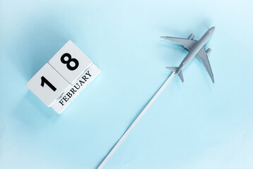 February calendar with number  18. Top view of calendar with flying passenger plane. Scheduler....