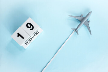 February calendar with number  19. Top view of calendar with flying passenger plane. Scheduler....