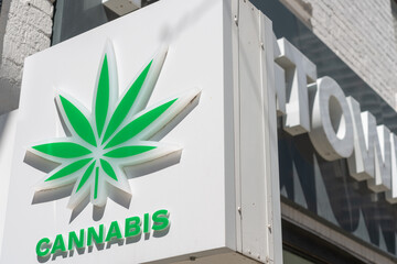 Fototapeta premium close-up of a projecting cannabis leaf sign outside Fogtown Flower and Cannabis Midtown located at 2152 Yonge Street in Toronto, Canada