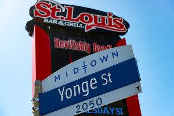 Fototapeta premium City of Toronto street sign near 2050 Yonge Street in the Midtown area of the city (St Louis Bar and Grill behind)