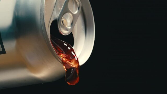 Red wine or soda liquid pouring out of silver can in super slow motion, black background of canned drink at 4k 800fps