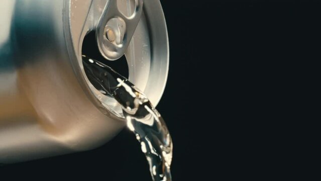 Clear beverage liquid pouring out of silver can in super slow motion, black background of clear drink beer or wine at 4k 800fps