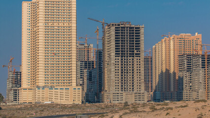 Fototapeta premium Modern new towers construction site in Ajman timelapse. Cityscape of Ajman.