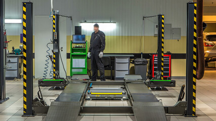 Car on stand with sensors on wheels for wheels alignment camber check in workshop of Service...