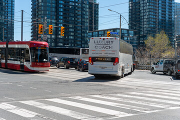 Obraz premium traffic at intersection in Toronto, Canada (featuring TTC streetcar, coach, cars, and trucks)
