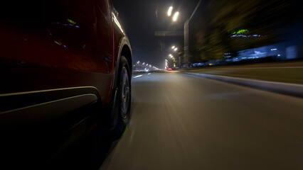 Obraz premium Drivelapse urban look from fast driving car at a night avenue in a city timelapse hyperlapse