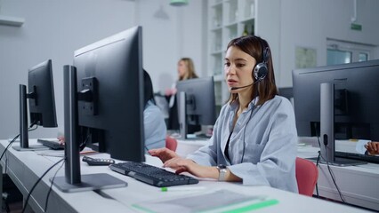 Young Brunette Woman Talking By Headset With Clients Of Bank In Call-Center, Working Day Of Employee
