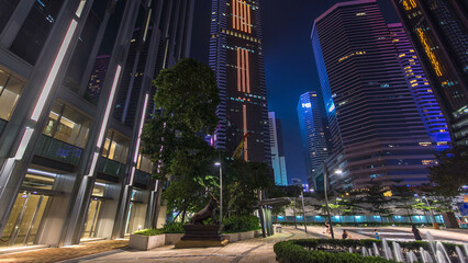 Night view hyperlapse of modern city in park with fountain and skyscrapers around. Time lapse. Hong...