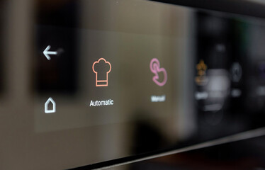 Close-up photo of touch screen controls on modern oven in kitchen