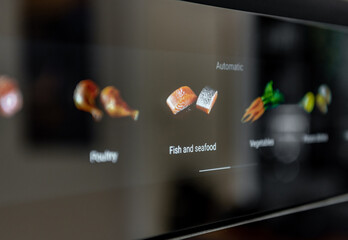 Close-up view of icons on touch screen controls on modern oven in kitchen