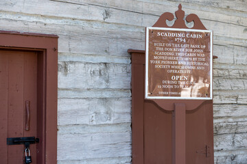 Obraz premium sign outside Scadding Cabin, a historical landmark, on the grounds of Exhibition Place located at 25 British Columbia Road in Toronto, Canada