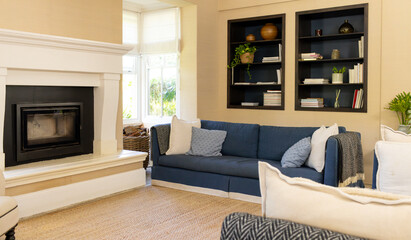 Living room with blue sofa, white armchair, and fireplace