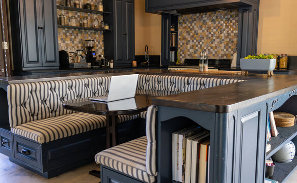 A modern kitchen with striped bench seating and large island