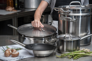 Chef at work with stainless steel cookware and fresh produce