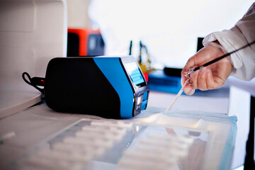 Scientist meticulously handling samples near advanced lab equipment.