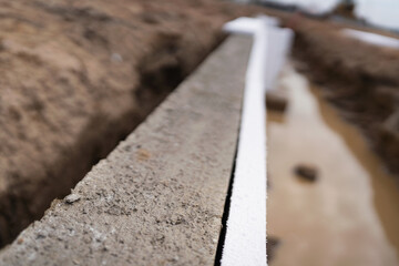 Close-up of a concrete wall with polyfoams at an industrial construction site - obrazy, fototapety, plakaty