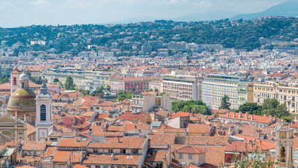 Fototapeta na wymiar Bright sun lights red roofs of the old city timelapse. Aerial view from Shatto's hill. Nice, France