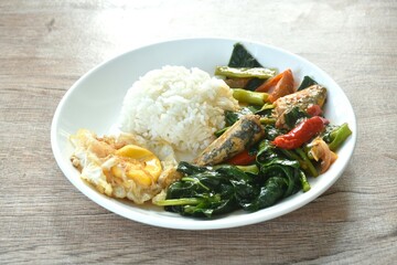 spicy stir fried Chinese kale with fish can in tomato sauce topping egg on plain rice in plate