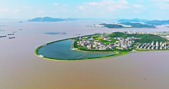 Aerial view of beautiful coastline and island with buildings landscape in Zhoushan, China. Drone shooting forward.
