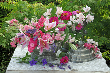 Still life floral display in vases outdoors on a table in a garden 