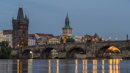 Fototapeta na wymiar The Charles Bridge day to night timelapse over the Vltava River reflected in water in Prague, Czech Republic