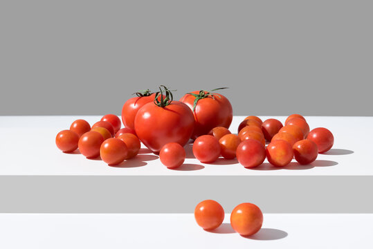 Surtido de tomates maduros sobre una mesa blanca y fondo gris