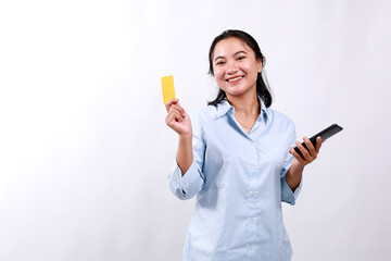 Asian woman holding credit card and looking at the camera, buying, order delivery in mobile phone application, standing over white background. Online shopping concept.