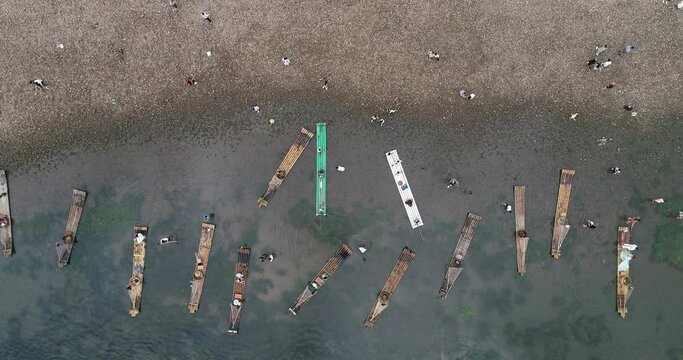 There are many bamboo rafts parked on the bank of the Li River for tourists to take photos
