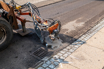 Asphalt milling and grinding scraper machine at road repair. Street renewal with machinery...