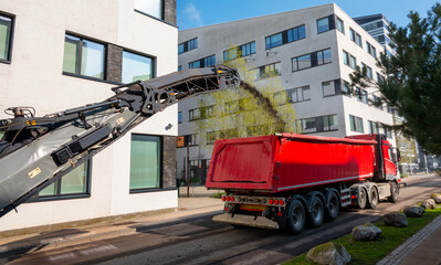 Asphalt milling and grinding scraper machine at road repair. Street renewal with heavy machinery...