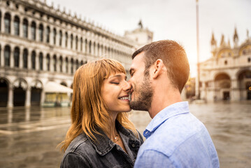 Happy cheerful young ouple travelling in Venice, Italy - Tourists visiting the historic city of Venice