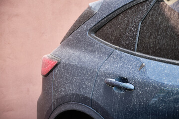 Car covered with windblown sand and dust from Sahara to Europe, after rain.