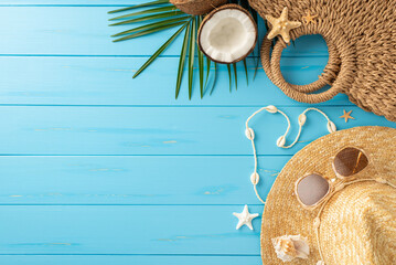 A vibrant display of summer beach essentials on a blue wooden background, featuring a straw hat,...