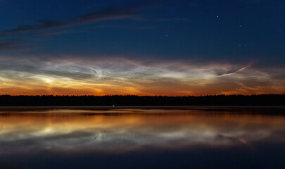 Beautiful sunset over the lake. Noctilucent clouds