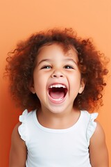 Smiling Portrait of a Young Girl with Curly Hair in a White T-Shirt Showing Her White Teeth Through Her Smile
