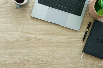 Modern workplace with laptop computer, coffee cup and pencils on wooden background. Top view.