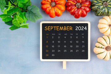View from above to simple September 2024 calendar decorated with pumpkin.