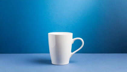 Close-up of ceramic white cup on isolated blue background. Tea or coffee mug. Drink ware. Mock up.